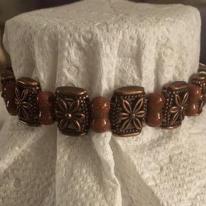 Copper color bracelet with sand stone look beads.